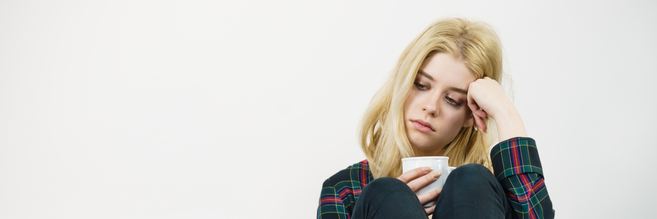 5 Absolutely False Things I Hear Too Often About Mental Illness Sad lonely woman sitting on couch with mug