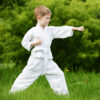 Boy practicing martial arts outdoors.