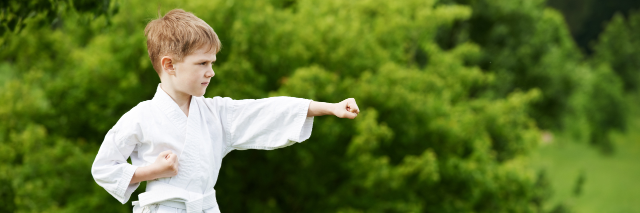 Encouraging Active Play for Children With Autism Boy practicing martial arts outdoors.