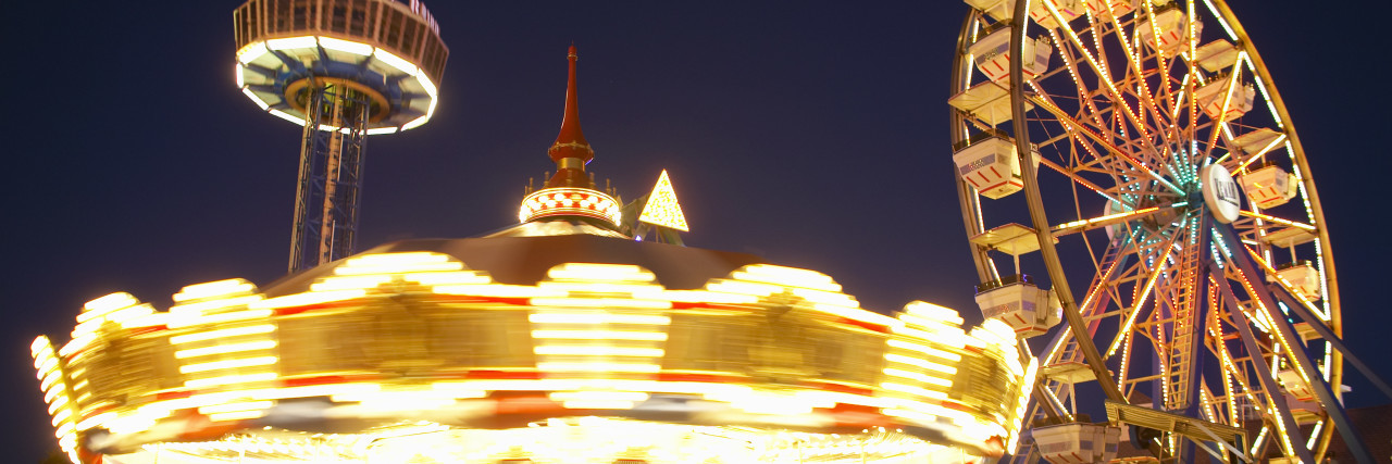 photo of a merry-go-round lit up at night, and ferris wheel