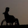 Woman in a wheelchair alone at night.