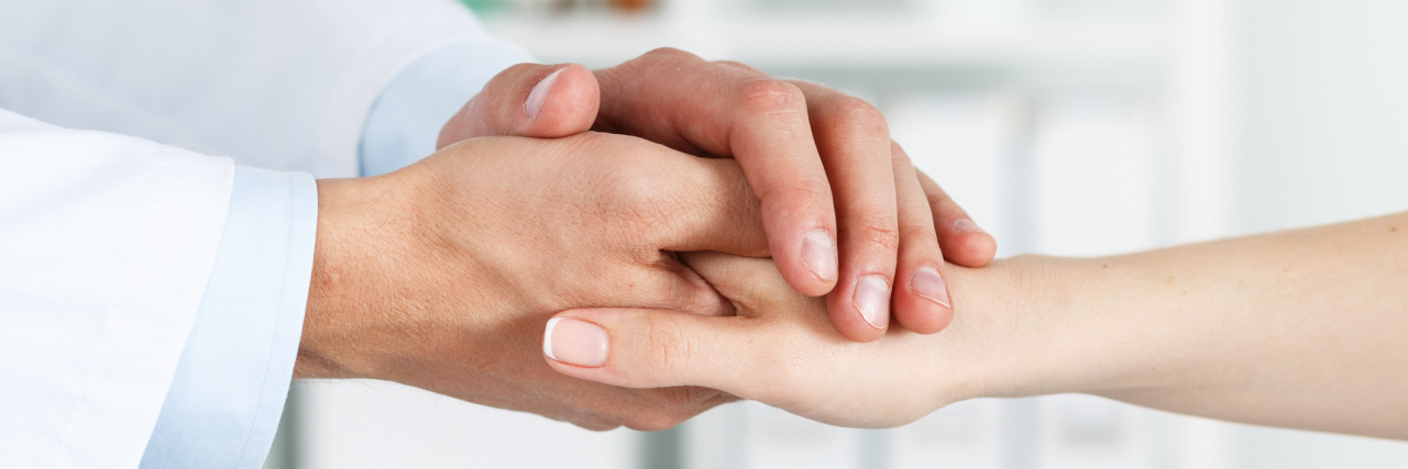 The Compassion My Medical Team Has Showed Me male doctor holding a female patient's hand comfortingly