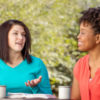 Two women talking outdoors.