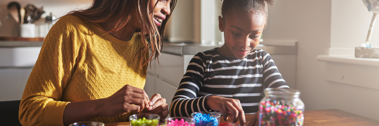 Mother and daughter creating beaded crafts.