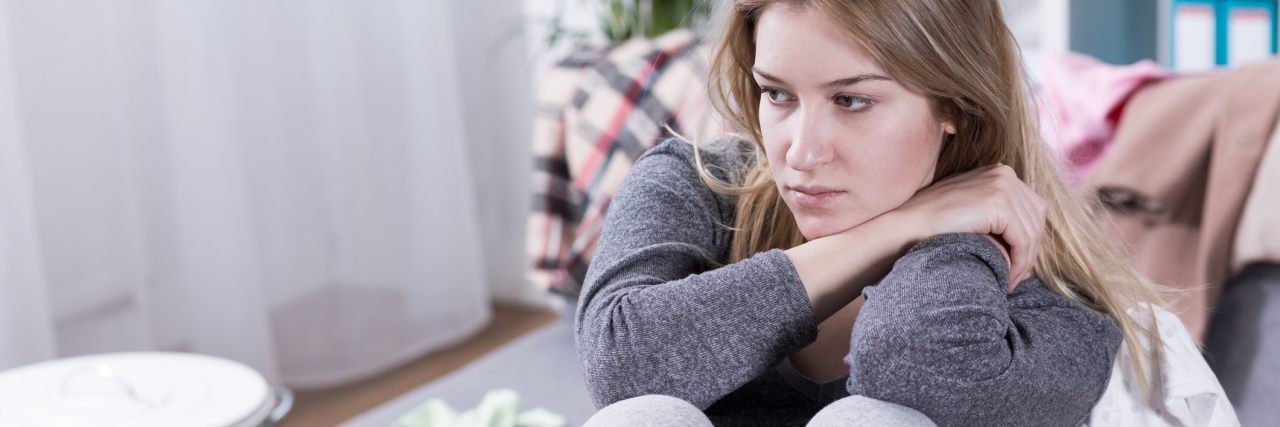 Does Anxiety Decrease With Age? photo of young mother looking worried and depressed in front of laptop with baby bottles nearby
