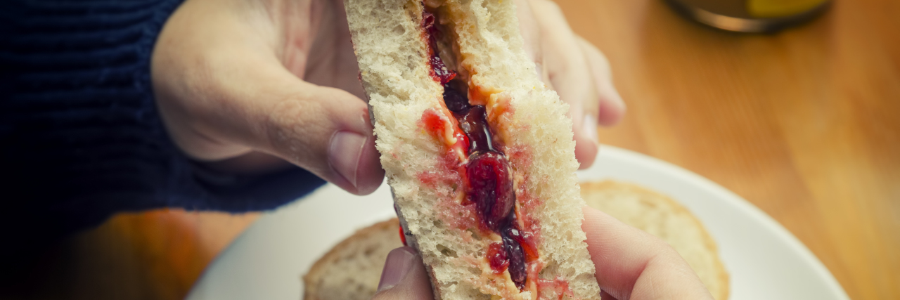 Eating a peanut butter and jelly sandwich.