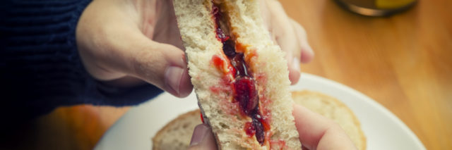 Eating a peanut butter and jelly sandwich.