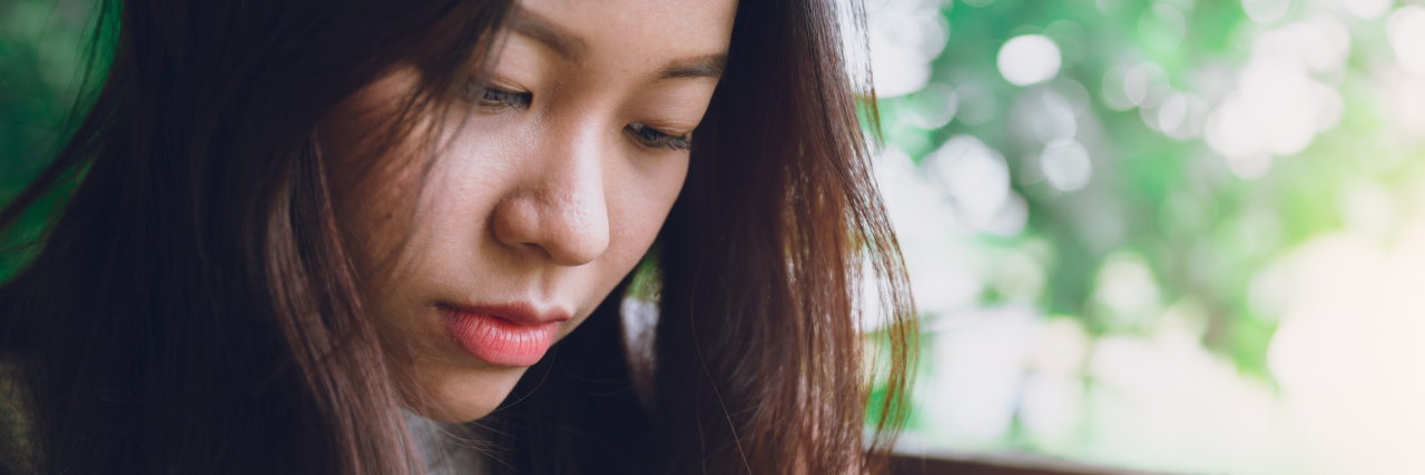 close up portrait photo of asian woman looking sad or depressed