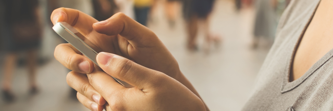 Why I Use My Phone at Work During a Panic Attack close up of a woman's hand using a mobile phone