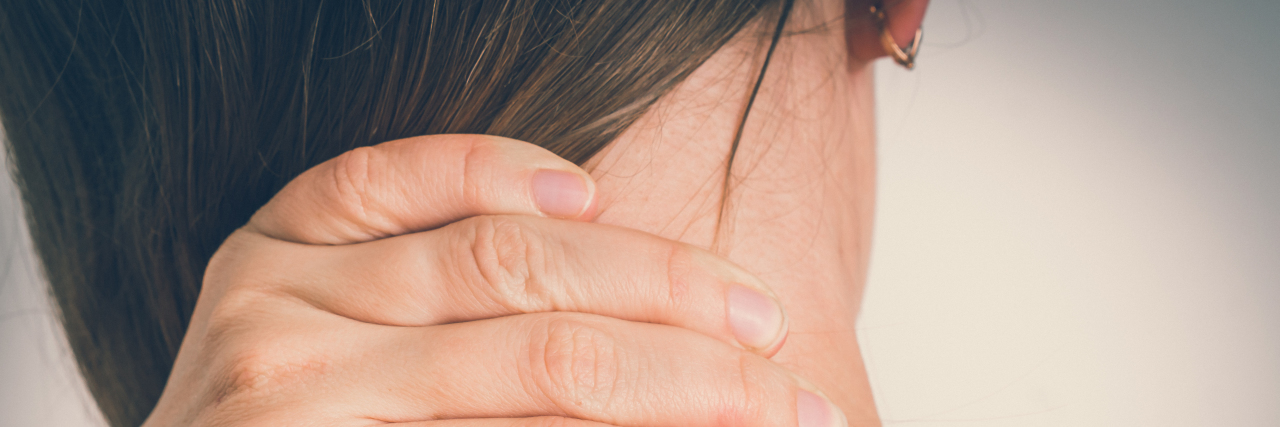 Myths About Living With Klippel-Feil Syndrome woman touching back of her neck in pain