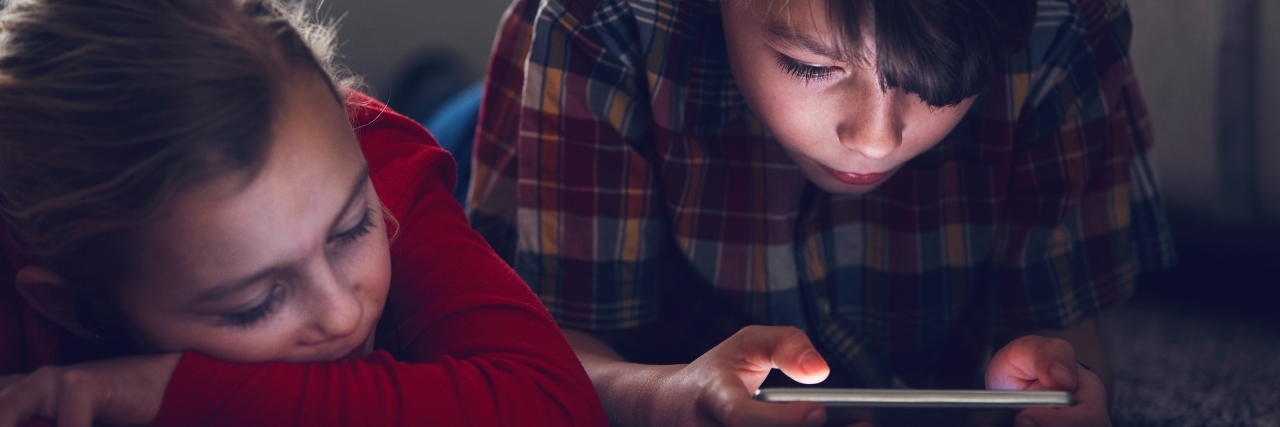 Mother Finds Suicide Instructions Spliced Into YouTube Kids Videos Little girl and boy watching video or playing games on their smart phones.