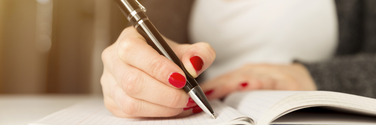 When Doctors Misdiagnose Ehlers-Danlos Syndrome Woman sitting and writing in a book