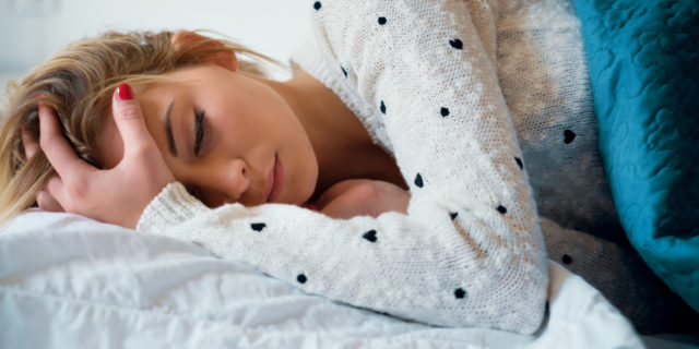 photo of woman lying in bed looking upset and alone