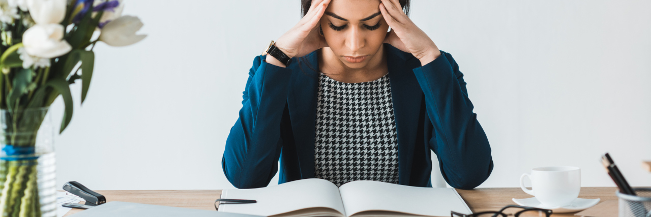 photo of young woman in office setting looking stressed