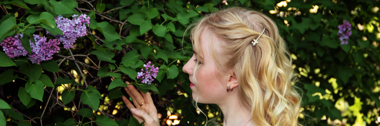 Woman admires lilac flowers.