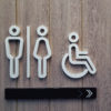 White disabled restroom symbols on wooden door.