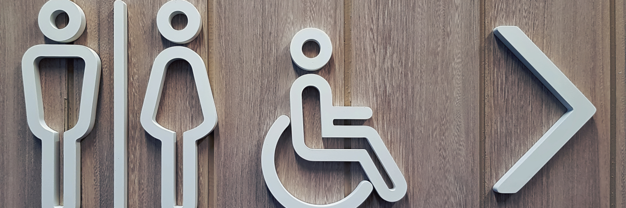 Shamed for My Invisible Disability by Two Disabled People White disabled restroom symbols on wooden door.