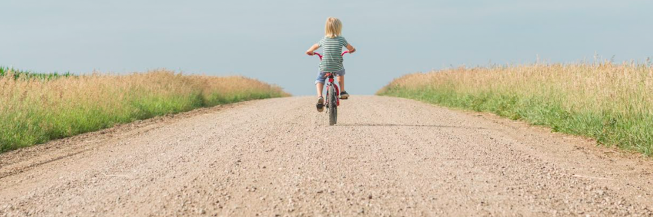 Global Commission Creates Roadmap to End Rare Diagnostic Odyssey boy on bike riding on a dirt road