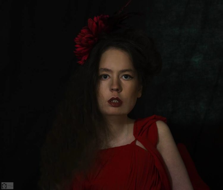 Jocelyn Woods in a red dress with red flower in hair