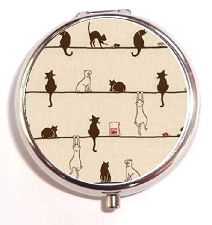 A circular pill box covered in cats.
