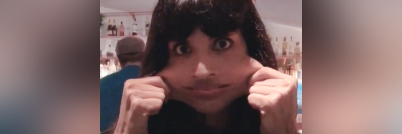 Jameela Jamil stretching her cheeks with the caption "I'm fine"