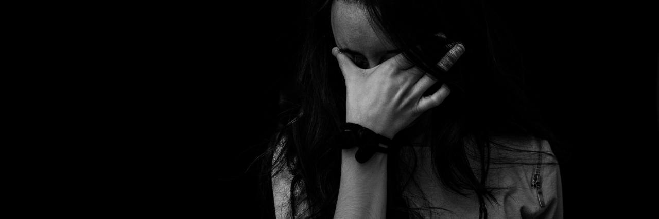 Struggling With Guilt Due to Chronic Illness black and white photo of tired looking woman with hand to eyes