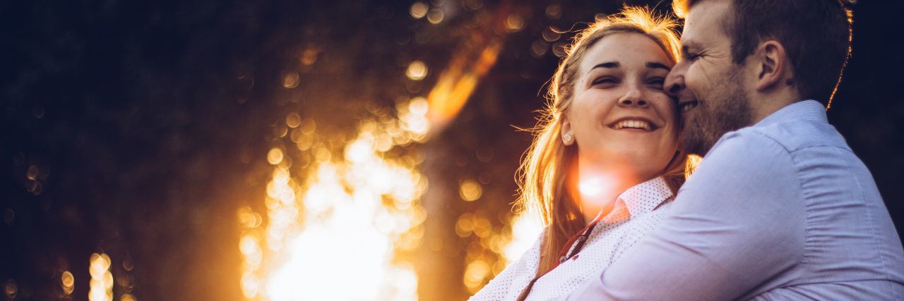 How to Strengthen Your Relationship With a Person With Bipolar photo of man and woman holding each other at sunset and smiling