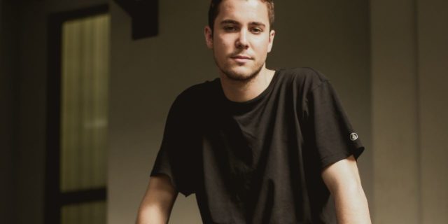 Why I Hide My MS Symptoms in Person but Not Online photo of young man sitting on wall wearing shorts and looking at camera