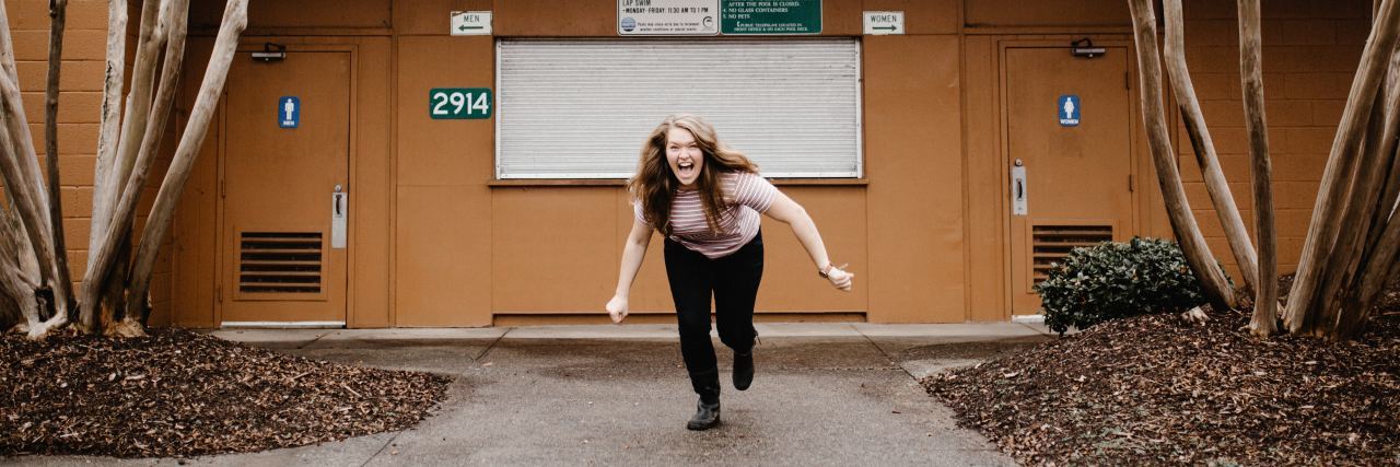 photo of woman laughing and running toward camera