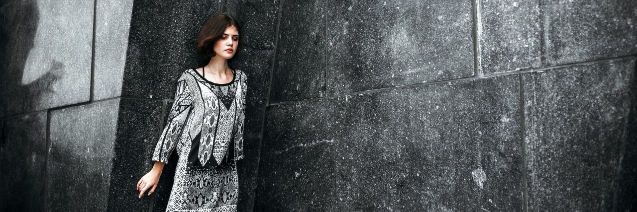 My Reaction to Getting My OCD Diagnosis photo of woman with short brown hair standing with her back to a wall and her eyes closed