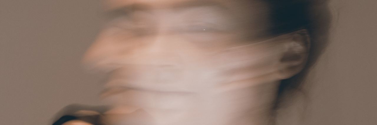 What to Do When PTSD Makes You Dissociate photo of woman looking away and blurred in motion