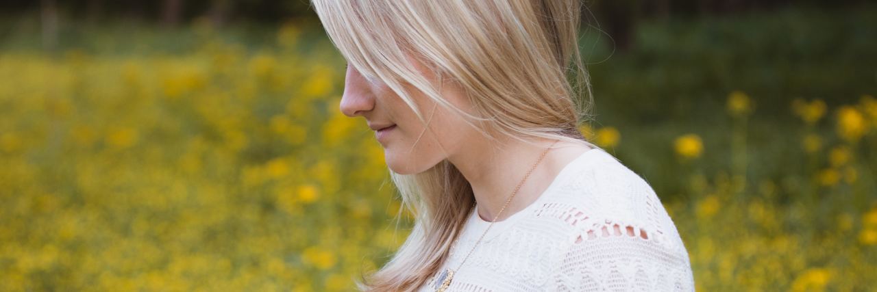 What to Expect From EMDR Therapy photo of blonde woman in profile view in meadow with yellow flowers and smiling