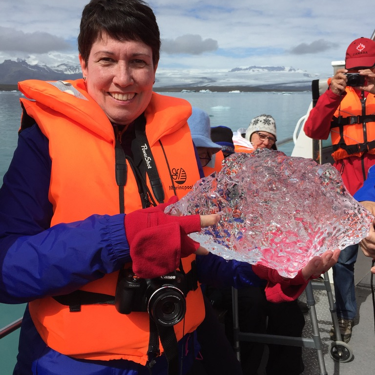 woman holding chunk of ice and smiling