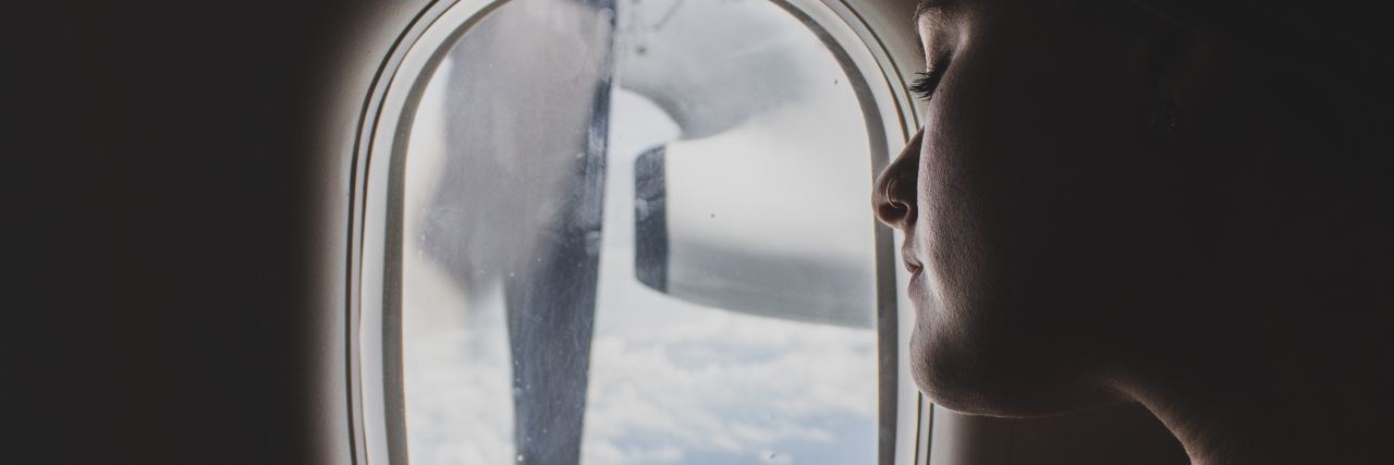 5 Tips for Preparing to Travel With a Mental Illness close up photo of woman looking out of window of plane