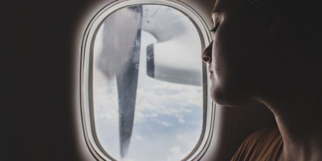 5 Tips for Preparing to Travel With a Mental Illness close up photo of woman looking out of window of plane