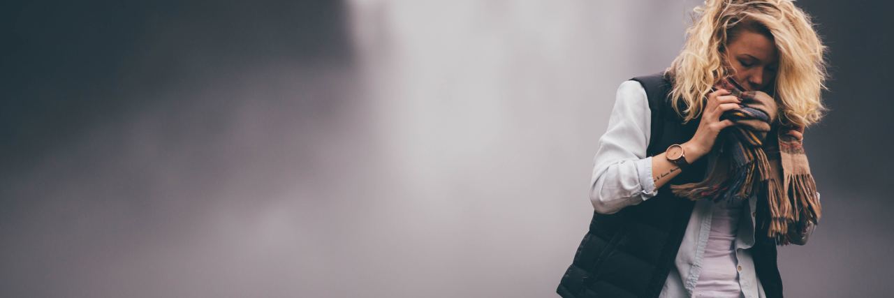 When You Have Bipolar Mania or Hypomania Without Euphoria photo of blonde woman standing in front of waterfall partially hiding face