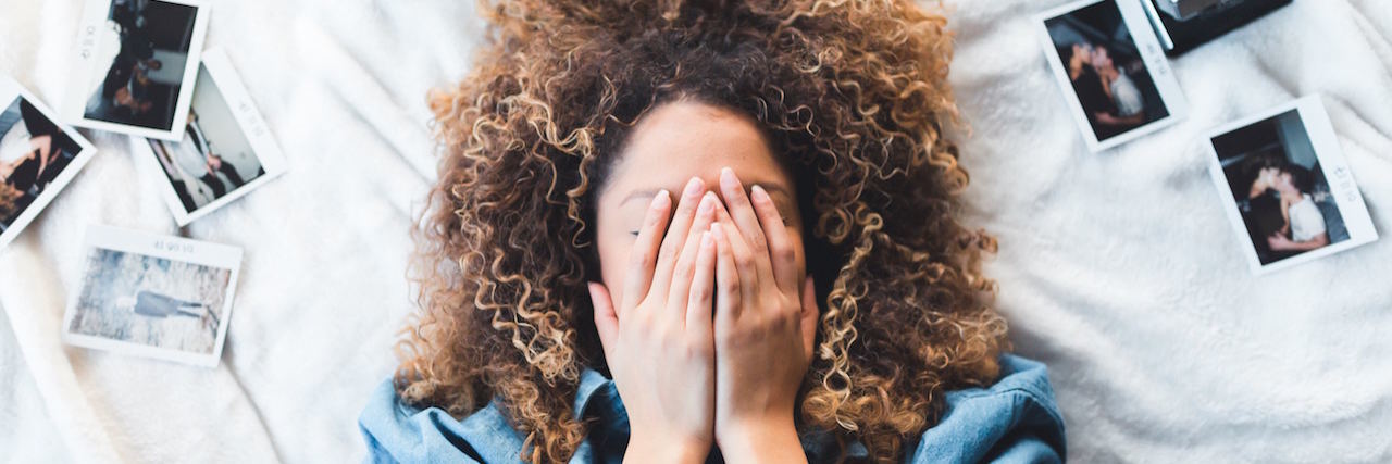 An Apology Letter From Your Anxiety A woman with her hands over her face, surrounded by photographs