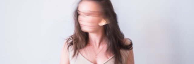 photo of woman turning head fast with blurred face