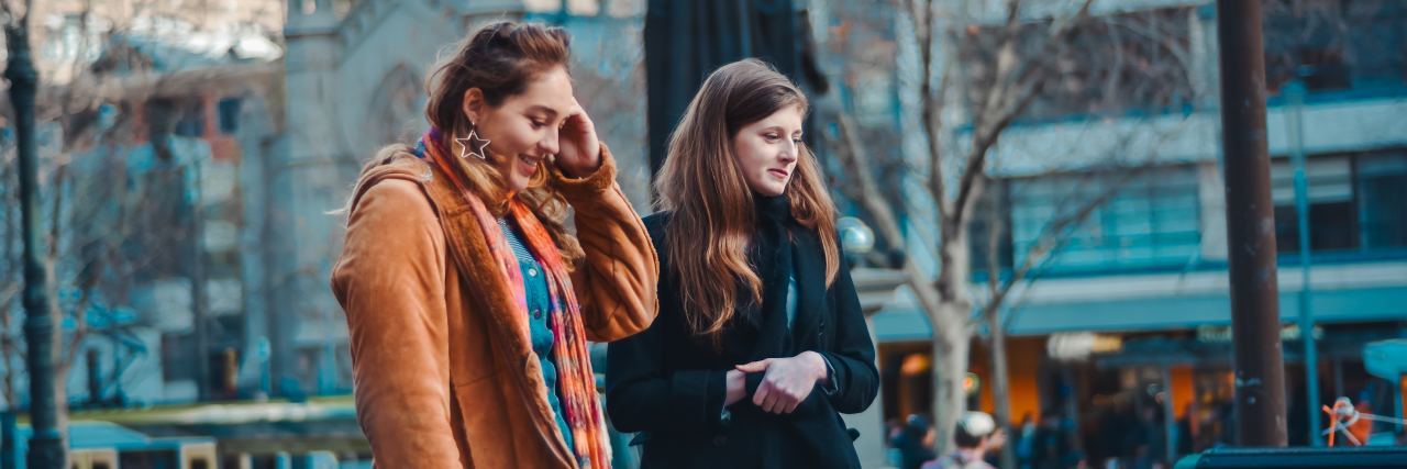 Why Everyone With a Chronic Illness Needs a 'Spoonie' Friend two women standing close together in public smiling
