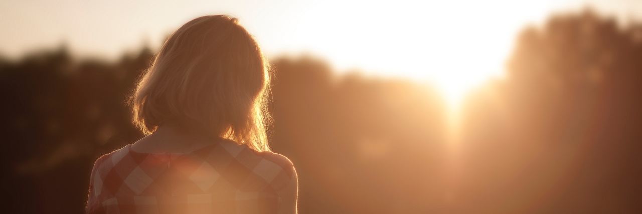 Why It's OK If You Don't Understand Chronic Pain Woman looking at the trees while the sun sets