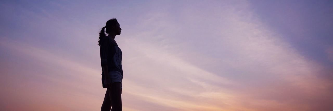 Setting Boundaries to Protect a Friendship Because of Mental Illness photo of woman standing alone silhouetted against sunset sky