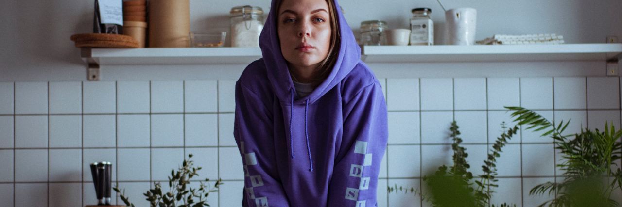 Why We Need to Leave Our Dissociative Identity Disorder Therapist photo of woman wearing purple hoodie sitting on countertop and looking into camera