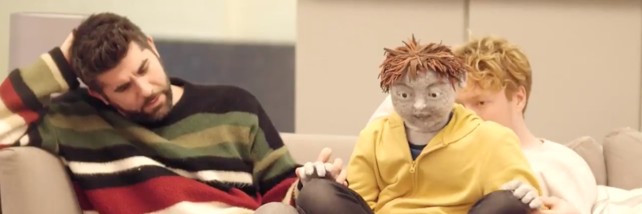 U.K. Play 'All in a Row' Uses Puppet to Portray an Autistic Character Screenshot of puppet with actor and puppeteer