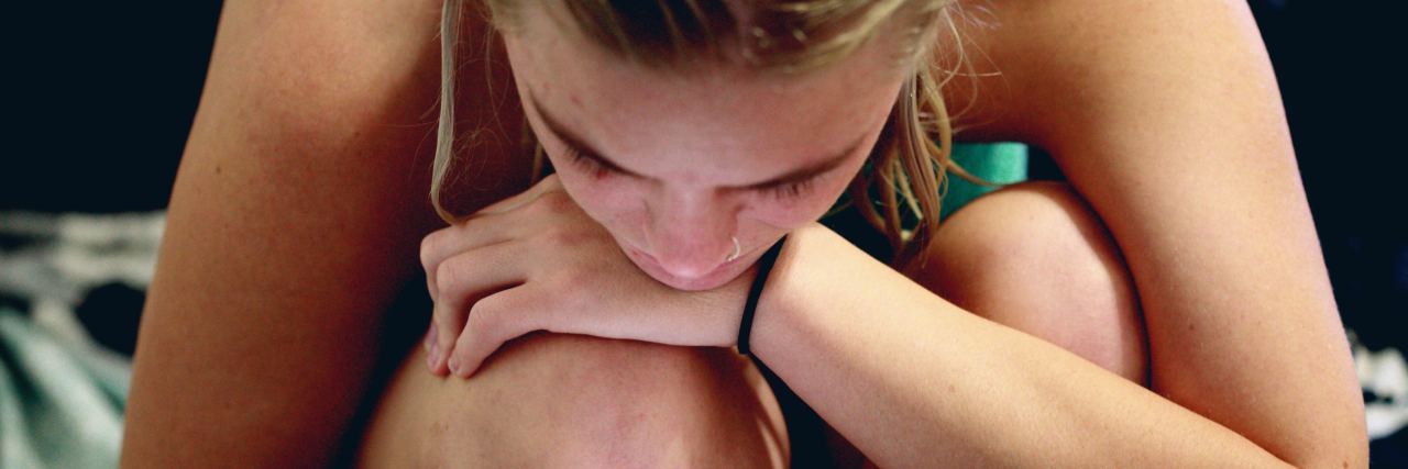 Social Media Causes Loneliness When You Live With BPD woman using phone while hugging knees