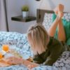 photo of woman lying on bed with healthy breakfast