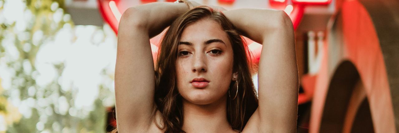 How I Experienced Fatphobia in Eating Disorder Treatment photo of woman posing in front of neon sign that says "fat pie"