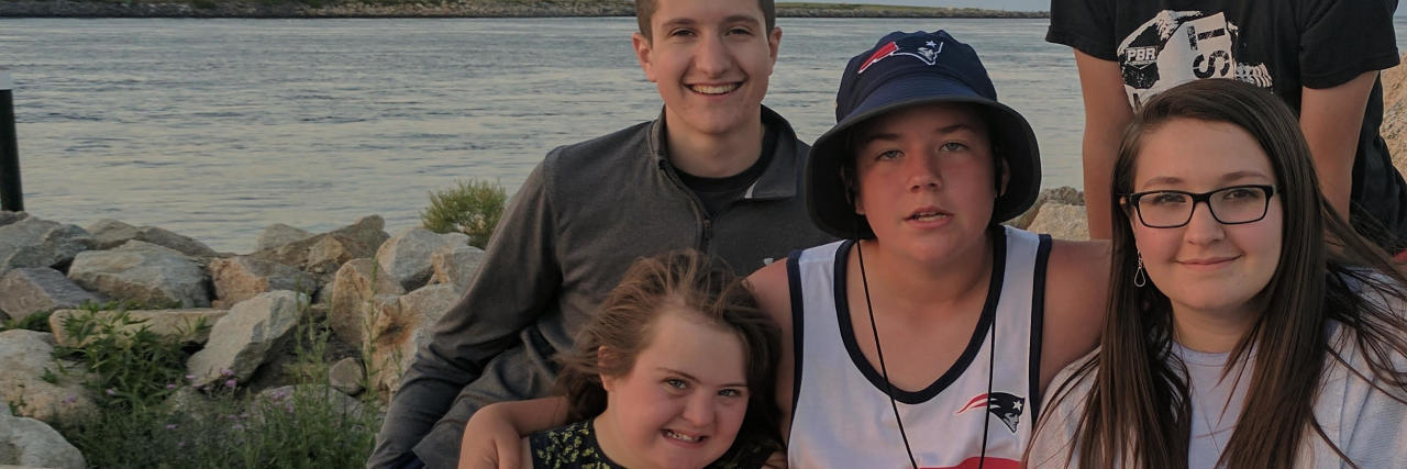 The Upside of Down Syndrome Moira's family sitting on a rocky beach.