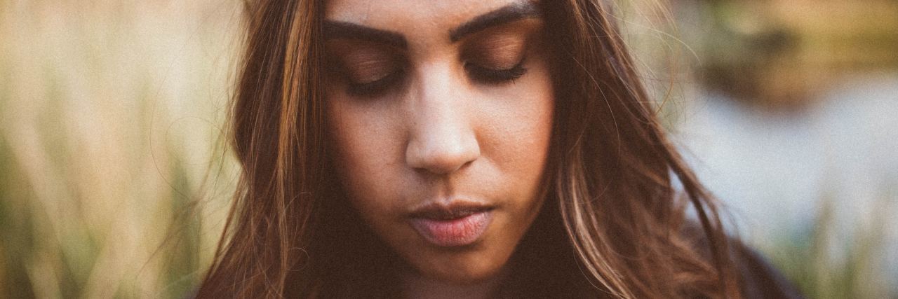 close up photo of indian woman with closed eyes looking sad