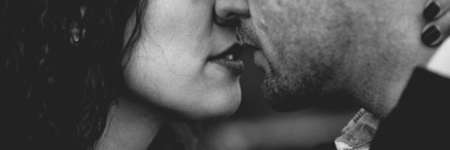 black and white photo of heterosexual couple kissing intimately