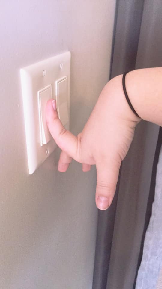 woman with ehlers-danlos syndrome hitting light switch with hypermobile finger